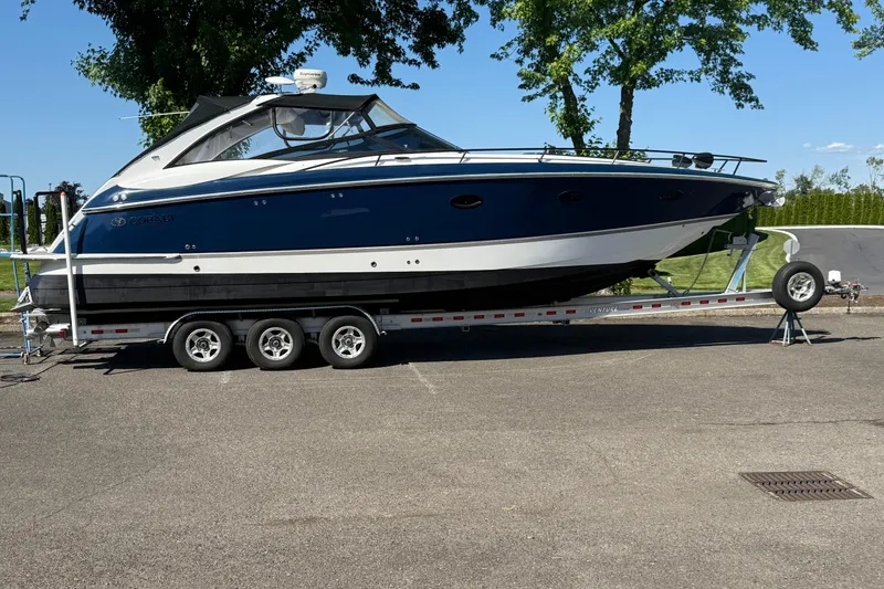 Slide: The Image of 2004 Cobalt 360 boat on trailer, parked outdoors under clear blue sky. - 21
