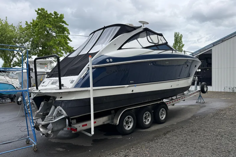 Slide: The Image of 2004 Cobalt 360 boat on trailer, parked outdoors near a storage facility. - 4