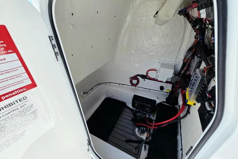 Slide: The Image of Interior view of 2026 Tidewater 2210 Carolina Bay boat wiring and storage compartment. - 19