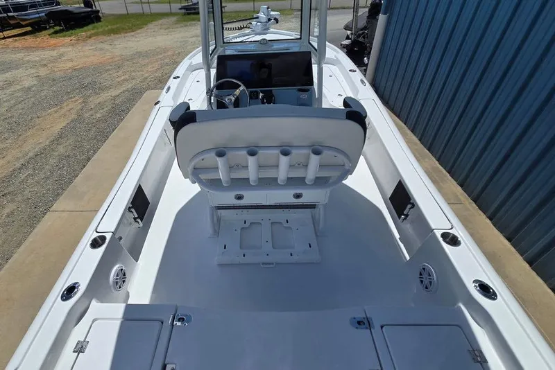 Slide: The Image of 2026 Tidewater 2210 Carolina Bay boat interior with helm and seating, docked beside a blue building. - 39