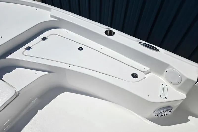 Slide: The Image of 2026 Tidewater 2210 Carolina Bay boat interior, featuring sleek white storage compartments and speaker. - 9