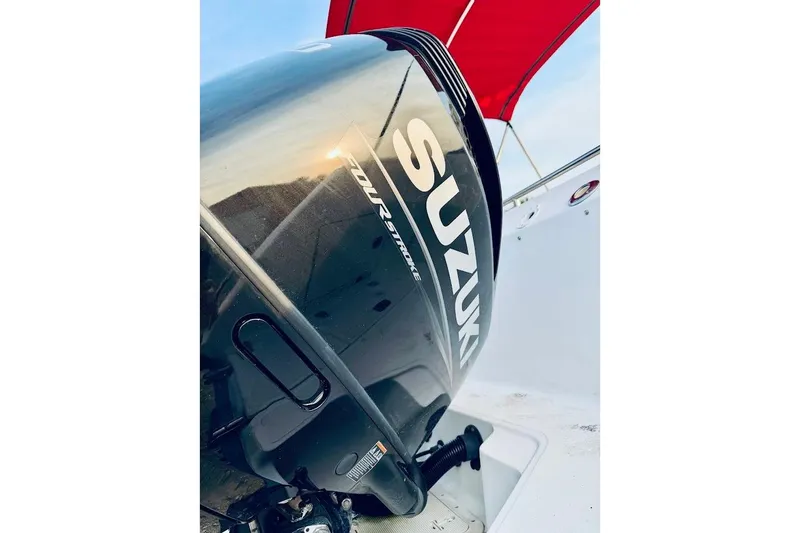 Slide: The Image of Suzuki outboard motor on a 2002 Boston Whaler 290 Outrage boat with red canopy. - 12