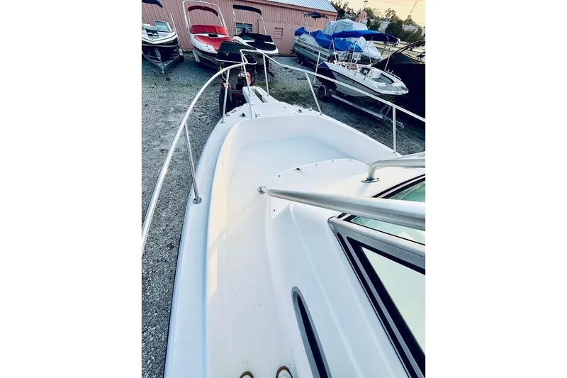 Slide: The Image of 2002 Boston Whaler 290 Outrage boat deck, parked among other boats in a storage area. - 36