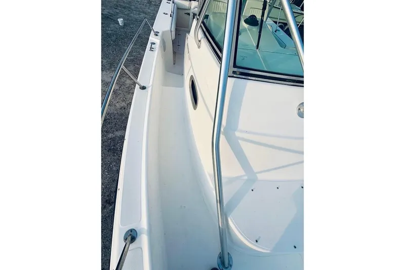 Slide: The Image of 2002 Boston Whaler 290 Outrage boat deck with stainless steel railings and clean white surface. - 39