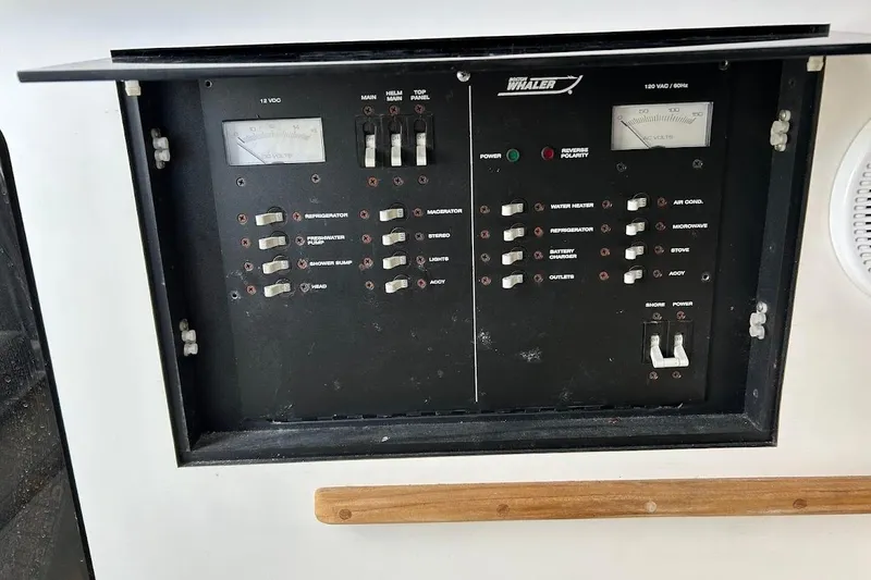 Slide: The Image of Control panel of a 2002 Boston Whaler 290 Outrage boat, featuring various switches and gauges. - 57