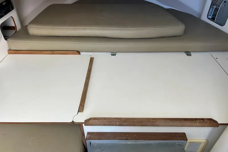 Slide: The Image of Interior cabin view of a 2002 Boston Whaler 290 Outrage boat with cushioned seating. - 60