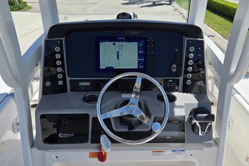 Slide: The Image of 2024 Robalo 246 Cayman boat dashboard with steering wheel and navigation system. - 10