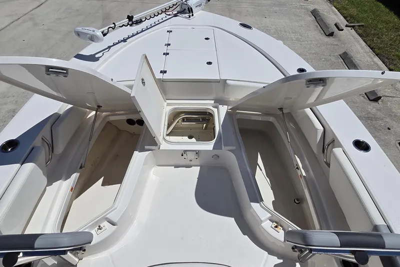 Slide: The Image of 2024 Robalo 246 Cayman boat interior with open storage compartments and seating. - 13