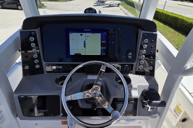 Slide: The Image of 2024 Robalo 246 Cayman boat dashboard with steering wheel and navigation display. - 19