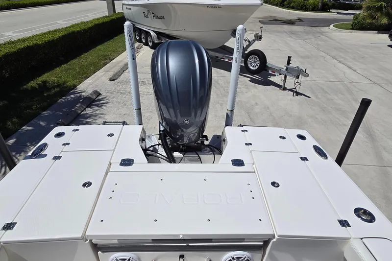 Slide: The Image of 2024 Robalo 246 Cayman boat with powerful outboard motor, parked on a trailer. - 21