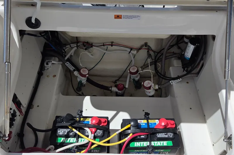 Slide: The Image of 2024 Robalo 246 Cayman boat battery compartment with wiring and components. - 22