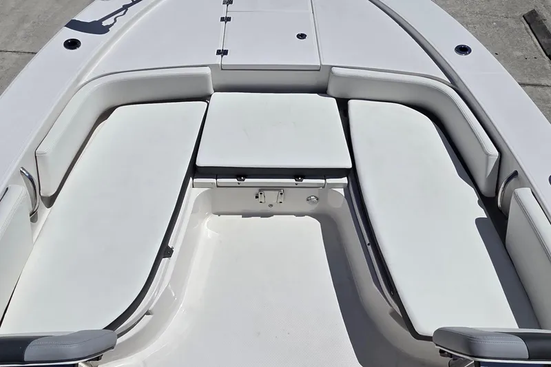 Slide: The Image of 2024 Robalo 246 Cayman boat interior with cushioned seating and storage compartments. - 6