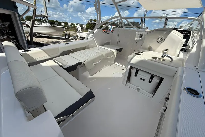 Slide: The Image of 2026 Edgewater 248CX Crossover boat interior with seating and amenities under a blue sky. - 11
