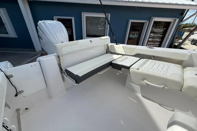 Slide: The Image of 2026 Edgewater 248CX Crossover boat interior with white seating and modern design. - 12
