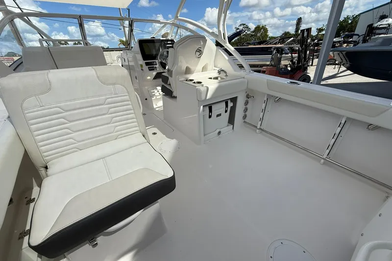 Slide: The Image of 2026 Edgewater 248CX Crossover boat interior with white seating and modern dashboard. - 13