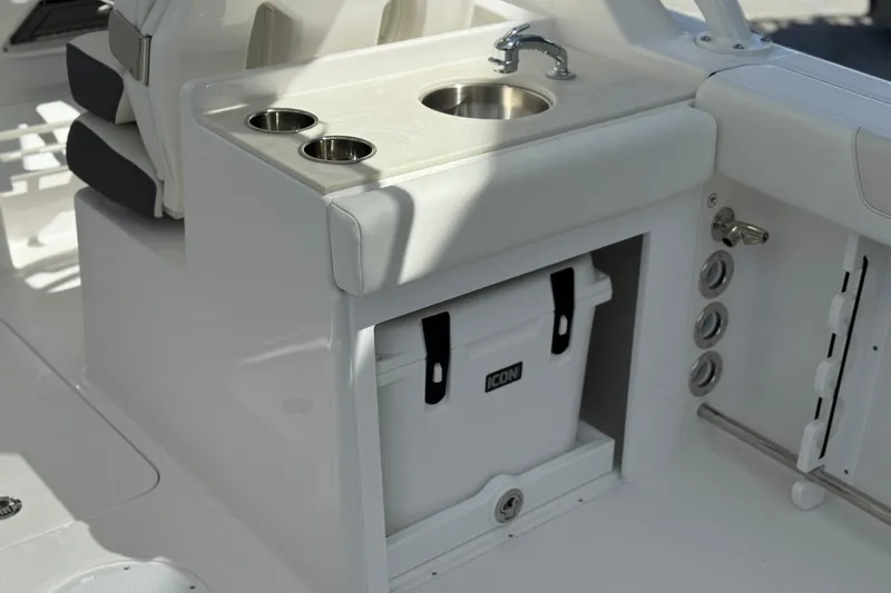 Slide: The Image of 2026 Edgewater 248CX Crossover boat interior with sink, cup holders, and storage compartment. - 14