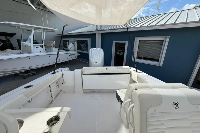 Slide: The Image of 2026 Edgewater 248CX Crossover boat interior with white seating and cup holders. - 15