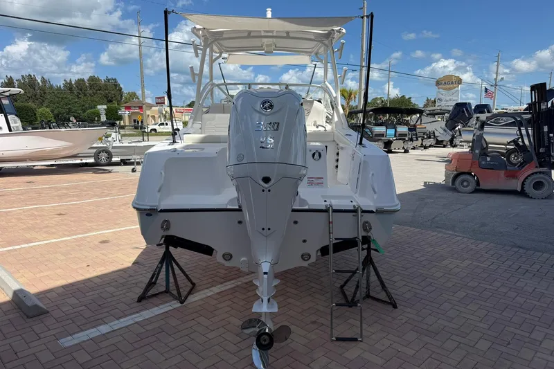Slide: The Image of 2026 Edgewater 248CX Crossover boat with powerful outboard motor in a sunny marina. - 6
