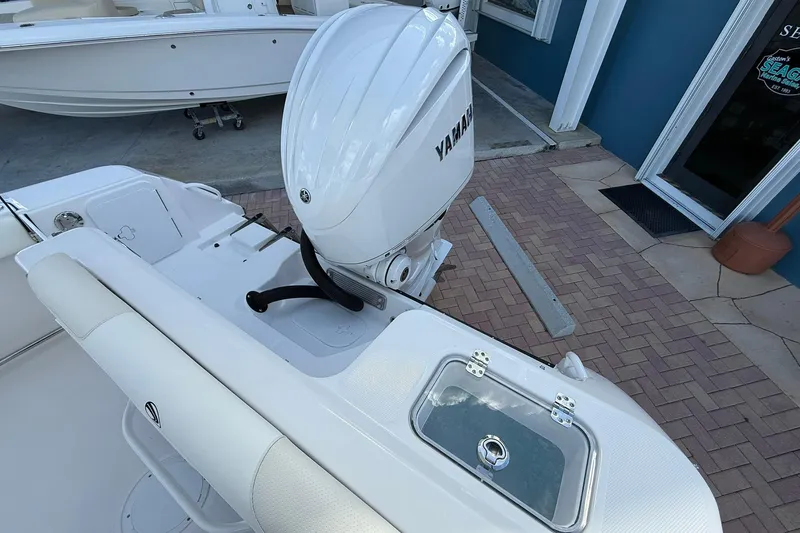 Slide: The Image of 2026 Edgewater 248CX Crossover boat with Yamaha outboard motor, docked on paved surface. - 7