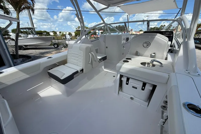 Slide: The Image of 2026 Edgewater 248CX Crossover boat interior with seating, sink, and storage. - 9