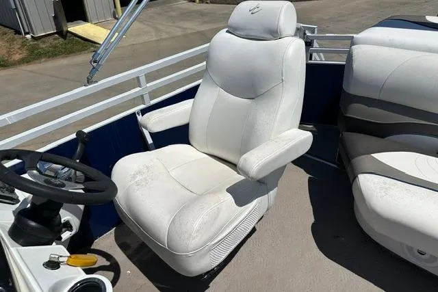 Slide: The Image of Captain's chair on 2013 JC 23 Neptoon TT boat, featuring white upholstery and steering wheel. - 17