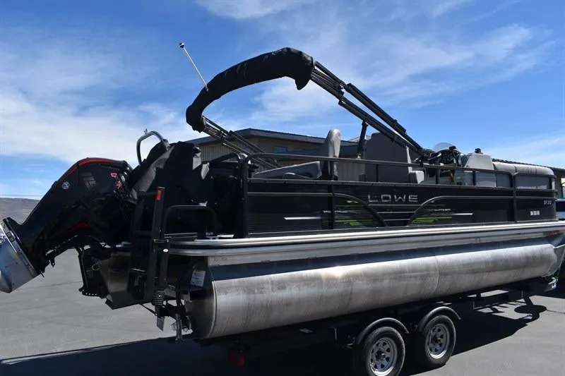 Slide: The Image of 2022 Lowe SF 212 Sport Fish pontoon boat on trailer under clear sky. - 12
