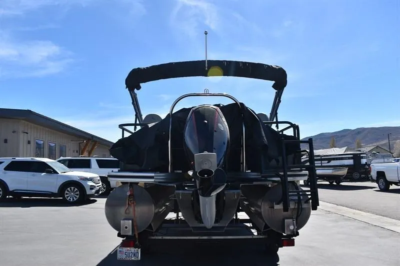 Slide: The Image of 2022 Lowe SF 212 Sport Fish pontoon boat with outboard motor, parked outdoors. - 13