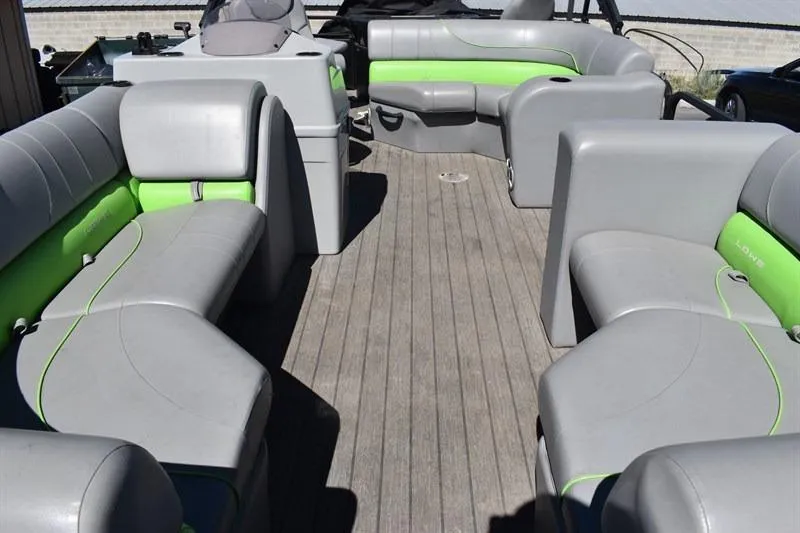 Slide: The Image of 2022 Lowe SF 212 Sport Fish pontoon boat with gray and green seating on wooden deck. - 14