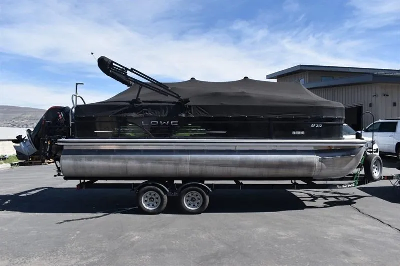 Slide: The Image of 2022 Lowe SF 212 Sport Fish pontoon boat on trailer, covered and parked outdoors. - 3