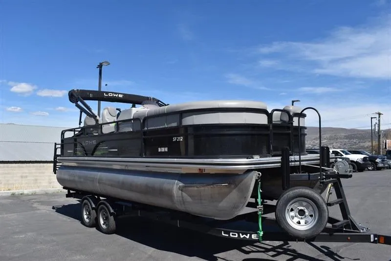 Slide: The Image of 2022 Lowe SF 212 Sport Fish pontoon boat on trailer under clear blue sky. - 8