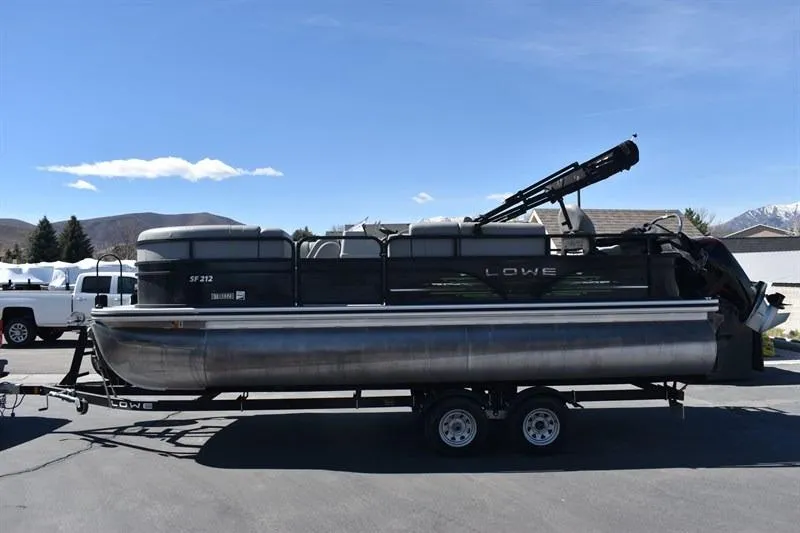 Slide: The Image of 2022 Lowe SF 212 Sport Fish pontoon boat on trailer, parked outdoors. - 9