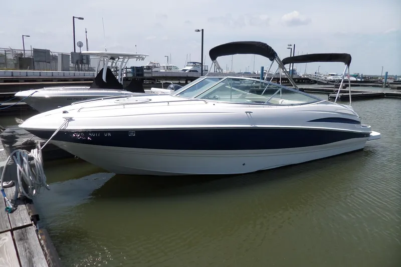 The Image of 2003 Maxum 2400 SC boat docked in marina, featuring sleek design and canopy. - 0
