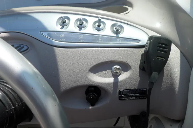 Slide: The Image of Control panel of a 2003 Maxum 2400 SC boat with switches and microphone. - 12