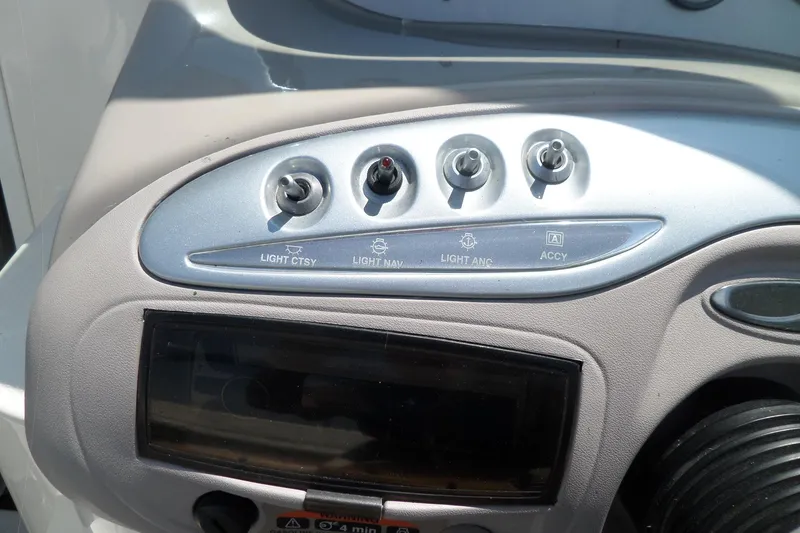 Slide: The Image of Dashboard controls of a 2003 Maxum 2400 SC boat, featuring light and accessory switches. - 13