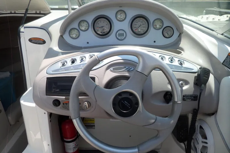 Slide: The Image of 2003 Maxum 2400 SC boat dashboard with steering wheel and control gauges. - 14