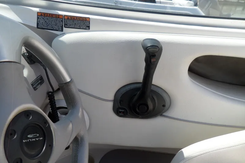 Slide: The Image of 2003 Maxum 2400 SC boat interior with steering wheel and throttle controls. - 16