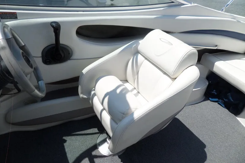 Slide: The Image of Interior of 2003 Maxum 2400 SC boat featuring a white captain's chair and steering wheel. - 17