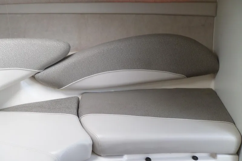 Slide: The Image of 2003 Maxum 2400 SC boat interior with gray and white cushioned seating. - 25