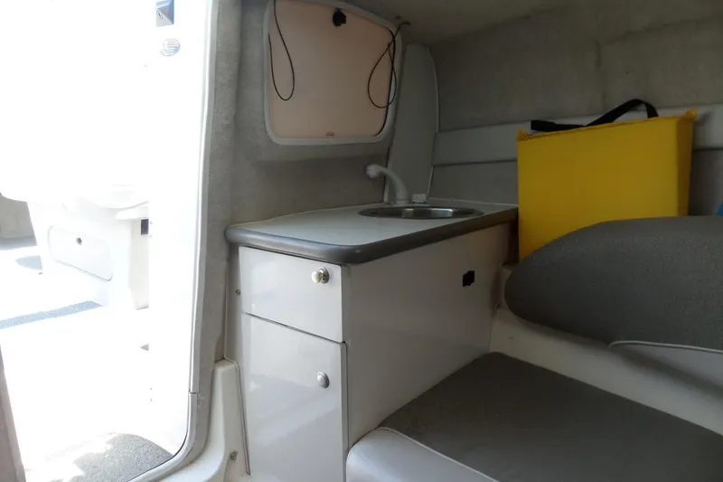 Slide: The Image of 2003 Maxum 2400 SC cabin interior with sink and seating area. - 27