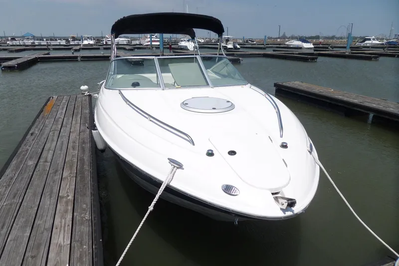 Slide: The Image of 2003 Maxum 2400 SC boat docked in a marina, featuring sleek white design. - 3