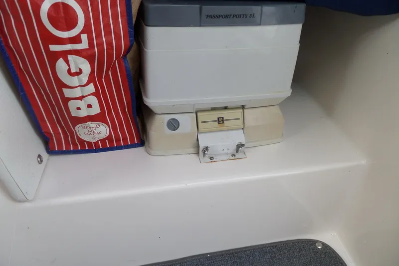 Slide: The Image of Portable toilet and storage bag inside a 2003 Maxum 2400 SC boat cabin. - 30