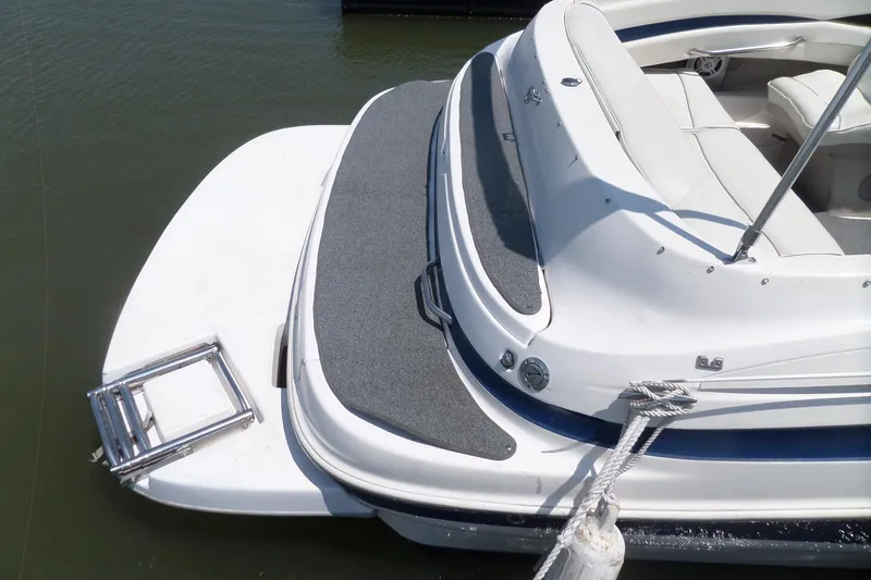 Slide: The Image of 2003 Maxum 2400 SC boat with swim platform and ladder, docked on calm water. - 4