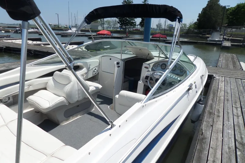 Slide: The Image of 2003 Maxum 2400 SC boat docked, featuring white interior and sleek design. - 5