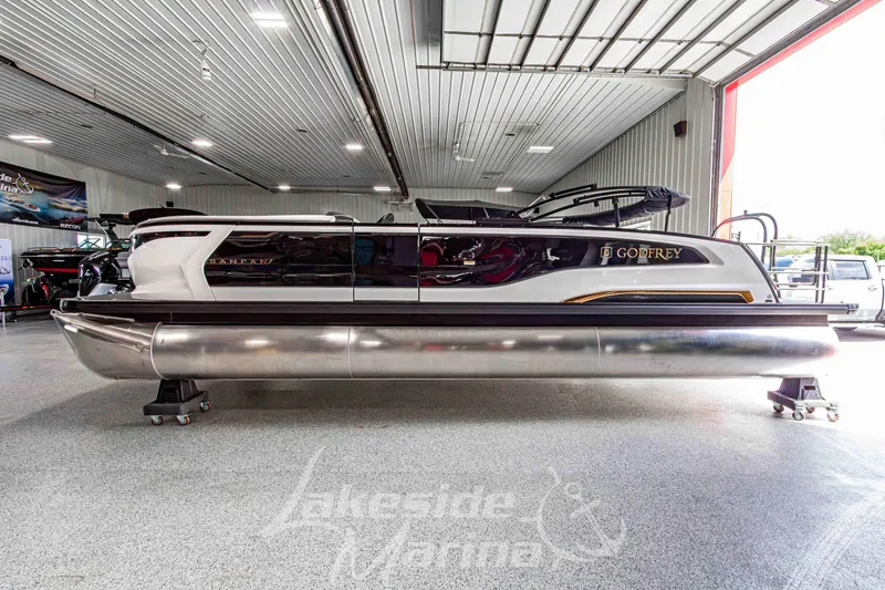Slide: The Image of 2026 Godfrey Sanpan 2700 MTF pontoon boat displayed in a showroom. - 1