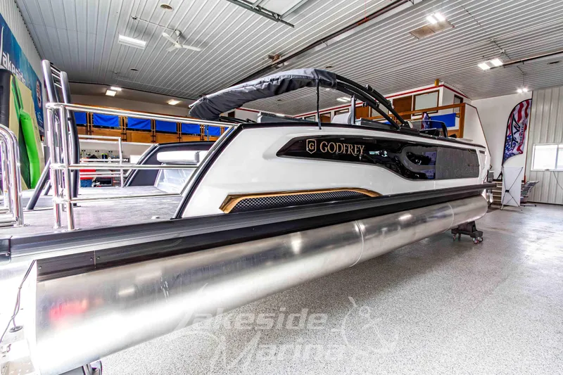 Slide: The Image of 2026 Godfrey Sanpan 2700 MTF pontoon boat in showroom, showcasing sleek design and modern features. - 3