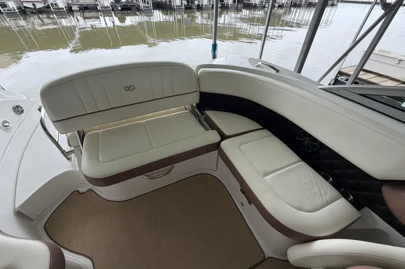 Slide: The Image of Interior seating of a 2012 Cobalt 242 boat, featuring white and brown upholstery. - 16