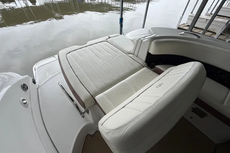 Slide: The Image of 2012 Cobalt 242 boat with white leather seating, docked by calm water. - 17