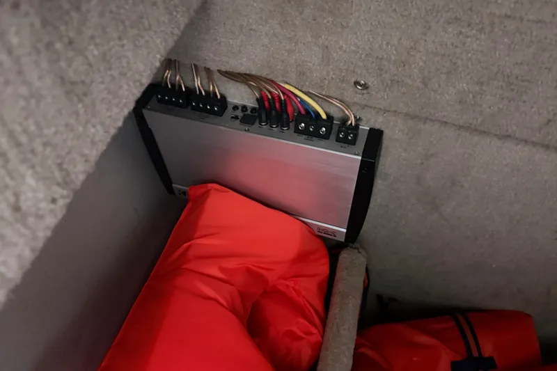 Slide: The Image of Audio amplifier and life jackets in a 2012 Cobalt 242 boat storage compartment. - 26