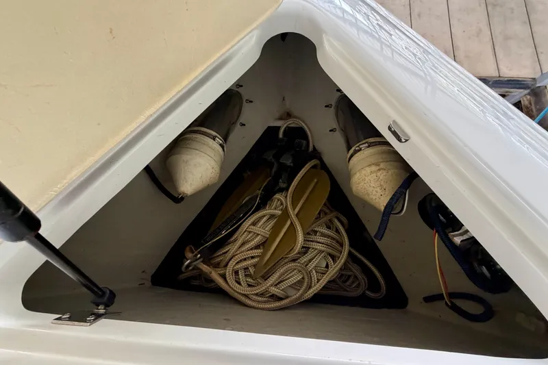 Slide: The Image of Storage compartment of a 2012 Cobalt 242 boat with ropes and equipment. - 32