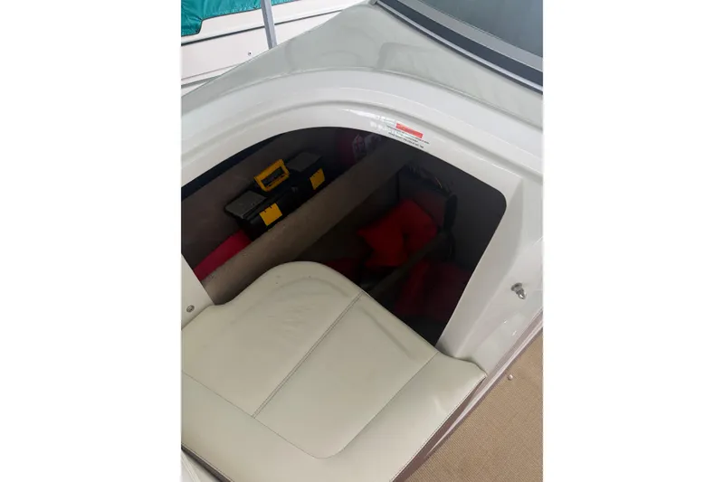 Slide: The Image of Storage compartment in a 2012 Cobalt 242 boat, featuring a white seat and toolboxes. - 39